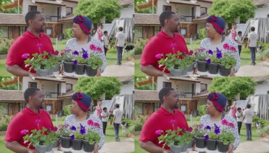 一对非洲裔美国夫妇拿着植物互相看着对方高清在线视频素材下载