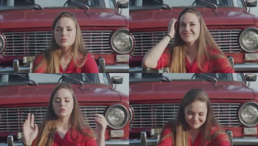 一位年轻女子坐在一辆旧车的引擎盖前。青春的乐趣和娱乐高清在线视频素材下载