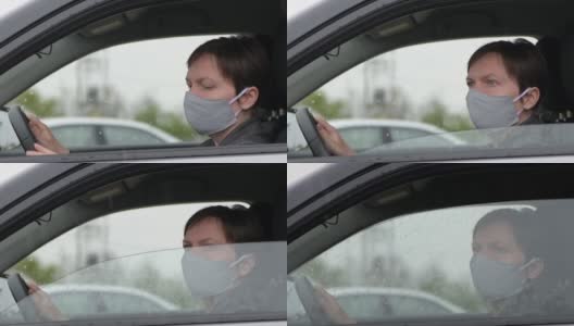 下雨天，一个带着防护面罩的忧心忡忡的女人在车里等着高清在线视频素材下载