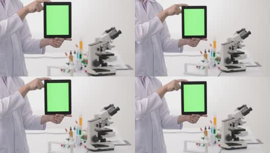 科学家和生物实验室用绿色屏幕的数字平板电脑做实验。4 k高清在线视频素材下载