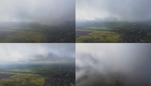 高空鸟瞰图，远处的城市被暴雨前形成的蓬松的积云所覆盖高清在线视频素材下载