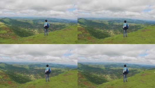 印度男性徒步旅行者看着美丽的绿色葱郁的山谷，从萨普塔拉萨哈德里山脉的总督山山顶在古吉拉特邦，印度。徒步旅行者从山上欣赏风景。高清在线视频素材下载