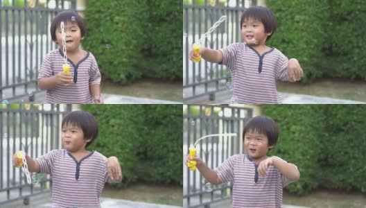 慢镜头:快乐的亚洲小男孩和他的妈妈在家里一起玩肥皂泡高清在线视频素材下载