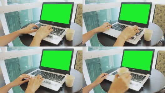 在咖啡馆用绿色屏幕的笔记本电脑工作高清在线视频素材下载