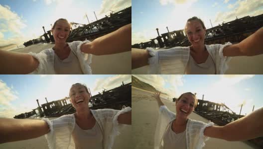 年轻女性站在Maheno沉船附近的自拍照高清在线视频素材下载