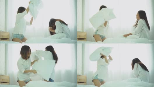两个年轻的亚洲女性朋友穿着白衬衫在早上一起玩枕头大战。在家里的卧室里，在床上度过有趣的时光。友谊的概念。高清在线视频素材下载