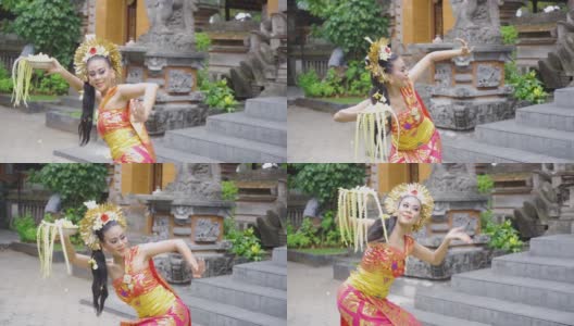 迷人的巴厘岛舞女拿着鲜花表演高清在线视频素材下载