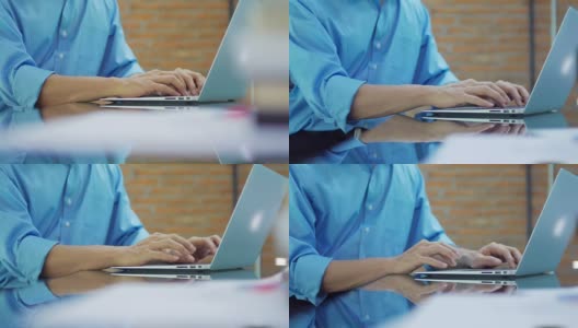 商人在办公室用笔记本电脑键盘打字，摄影车从右向左拍摄高清在线视频素材下载