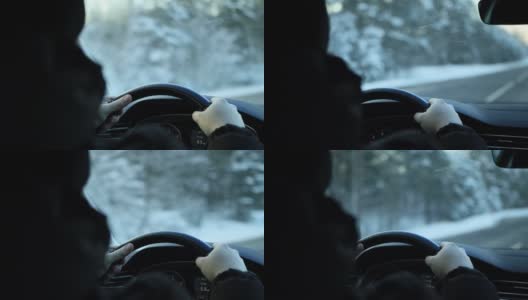 男人的手握着一辆轿车的方向盘，冬天自驾游。下雪的森林,背景。文本的复制空间高清在线视频素材下载