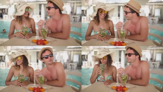一对情侣在泳池边喝夏日鸡尾酒高清在线视频素材下载