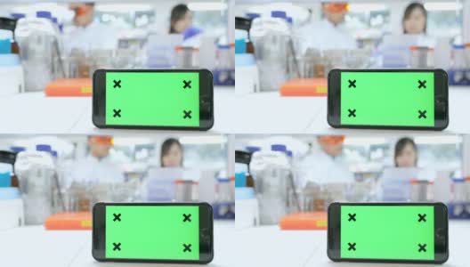 智能手机绿色屏幕背景与科学家在实验室工作高清在线视频素材下载