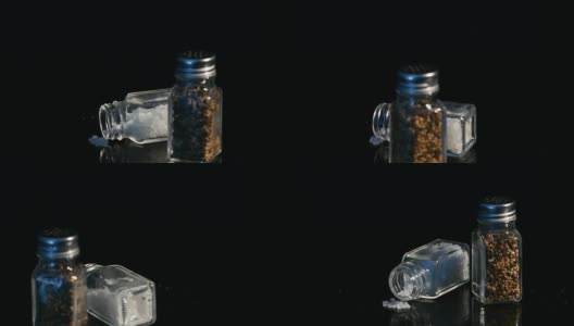 海盐和黑胡椒在玻璃罐中展示在黑色的背景高清在线视频素材下载