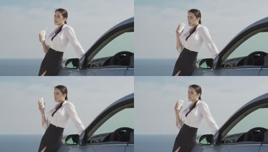 自信的年轻女商人站在她的汽车旁边，对着天空高清在线视频素材下载