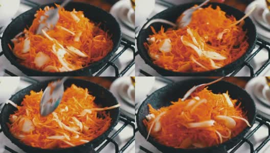 切片的胡萝卜和洋葱一起在煎锅里炸，蔬菜是炖的高清在线视频素材下载