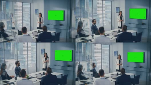 办公室会议室会议介绍:亚洲女商人谈话，使用绿屏彩色键墙电视。成功地向众多投资者展示产品。商人们鼓掌高清在线视频素材下载