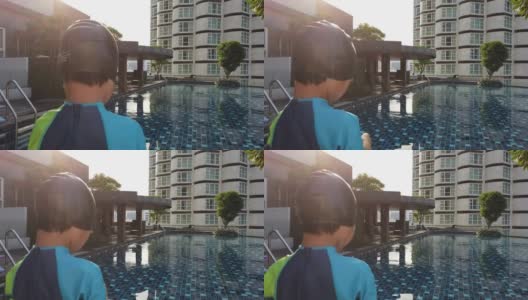 小男孩站在公寓游泳池边上准备跳下去锻炼。高清在线视频素材下载