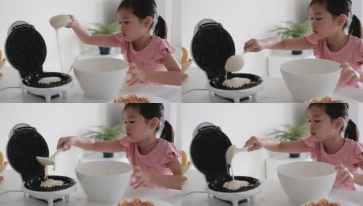 年轻的混合亚洲女孩帮助在家里做华夫饼的早餐，家庭教育，蒙特梭利教育的概念高清在线视频素材下载