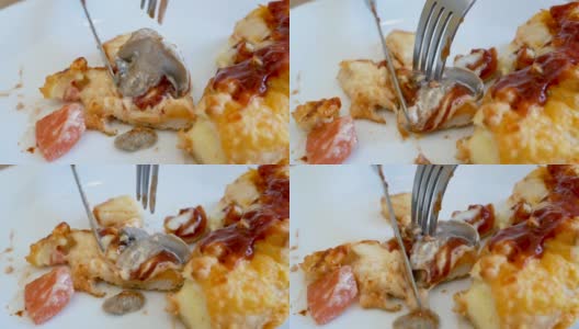 在餐馆里，年轻的亚洲妇女用刀把披萨切成小块，然后用叉子把它叼进嘴里。高清在线视频素材下载