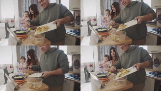 爸爸用剩菜做堆肥的慢动作视频，他的妻子和女儿和他在厨房里高清在线视频素材下载
