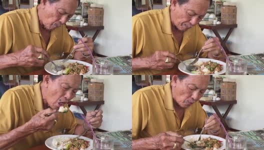 亚洲高级男子吃米饭和炒罗勒与肉末高清在线视频素材下载