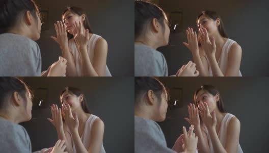 一位美丽的母亲和一个亚洲女儿在卧室里给女儿的手涂指甲油高清在线视频素材下载
