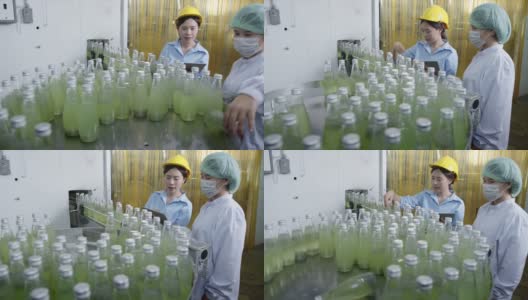 亚洲女主管在饮料加工厂检查药草饮料生产线。女工检查瓶中饮料产品流水线加工厂工业理念高清在线视频素材下载