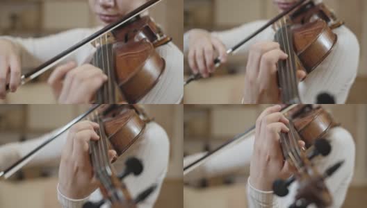 女职业音乐家拉小提琴特写，背景模糊高清在线视频素材下载