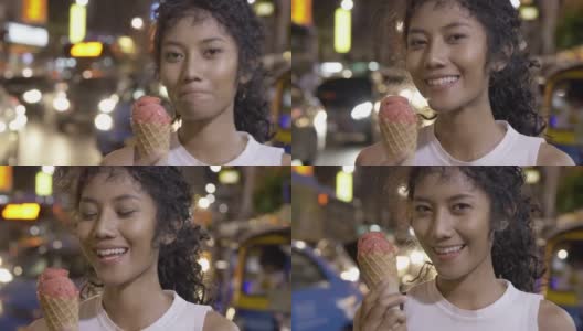 美丽的亚洲女人在夜市吃冰淇淋的肖像。高清在线视频素材下载