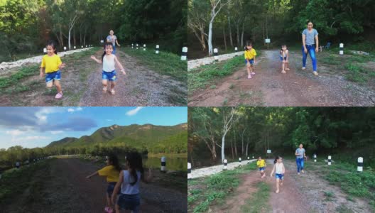 夏日公园里快乐的家庭跑步。夕阳西下，母亲和孩子们在路上奔跑。全家人一起度假。高清在线视频素材下载