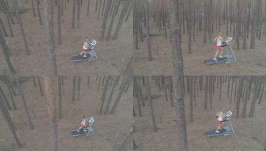空中镜头。一名年轻女子在森林里的跑步机上跑步。高清在线视频素材下载
