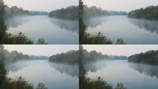 水上有烟。清晨拂晓时，雾漂浮在河上。绿色森林衬托下的美丽湖泊。大自然迷人的奇迹。水表面。文本的复制空间高清在线视频素材下载