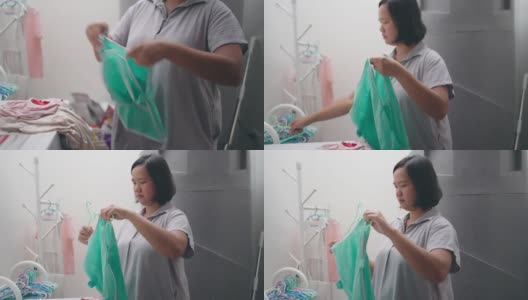 妇女在洗完衣服后挂湿衣服高清在线视频素材下载