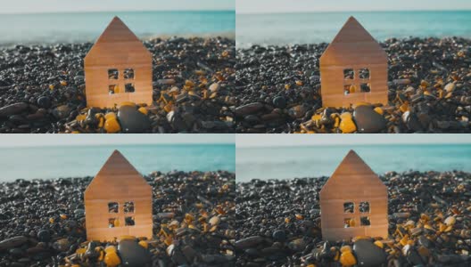海边卵石海滩上的硬纸板房子的特写。抵押与租赁概念高清在线视频素材下载