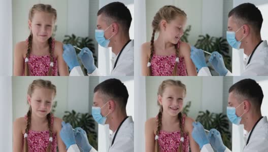 一名戴着医用口罩的医生在一个孩子的肩膀上注射。疫苗接种对冠状病毒。COVID-19疫苗。医生给孩子打了疫苗。一个小女孩在打流感疫苗。高清在线视频素材下载