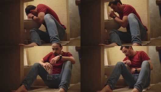 一名男子在厕所里用手托着头和肚子坐在地上呕吐高清在线视频素材下载