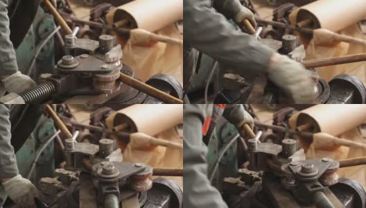 一名工人在弯管机上工作，弯管并取出成品金属坯高清在线视频素材下载