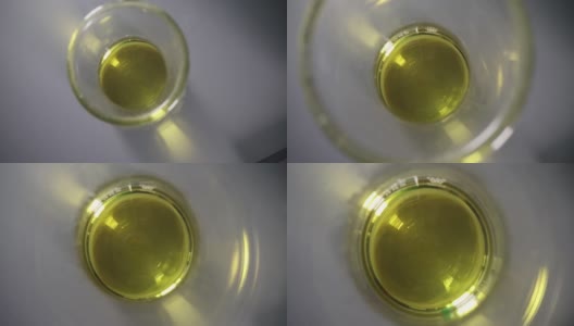 透明黄色油在玻璃化学试管的特写高清在线视频素材下载