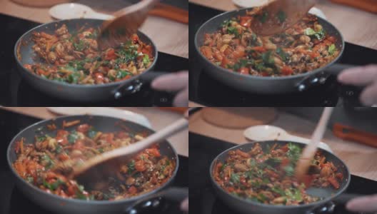 厨师用木勺在煎锅中搅拌食材。高清在线视频素材下载
