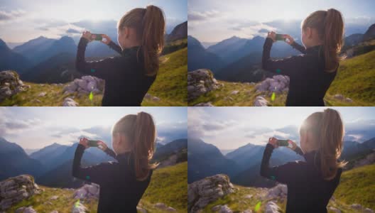 一个女人用智能手机在山坡上拍照高清在线视频素材下载