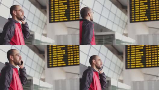 年轻男性通过智能手机在机场等待航班高清在线视频素材下载