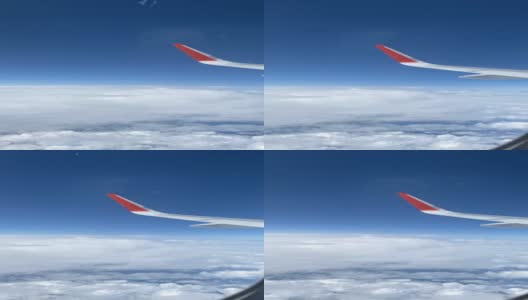从飞机窗口看到的云朵和飞机的机翼。高清在线视频素材下载