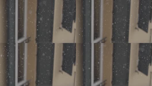雪花在风雪中飘落在院子里，拉近了窗户的细节。缓慢的运动。高清在线视频素材下载