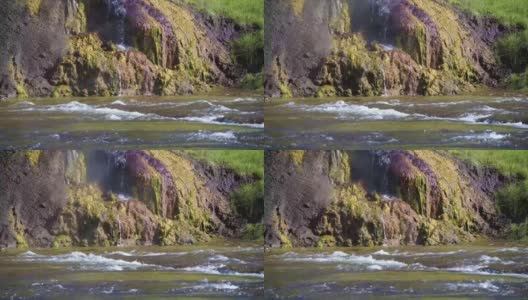 令人惊叹的无人机特写镜头，热气腾腾的水从岩石顶部流动高清在线视频素材下载