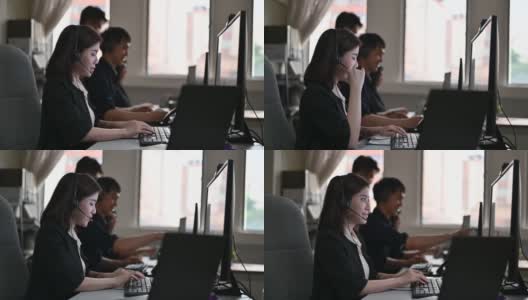 年轻的亚洲呼叫中心女接线员戴着耳机在电脑上工作高清在线视频素材下载