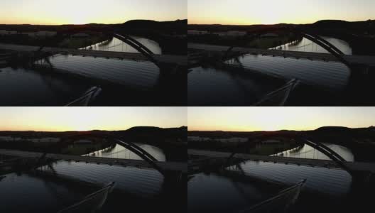 太阳落在360桥或Pennybacker桥和船下桥下的剪影辉光在德克萨斯山后下沉高清在线视频素材下载