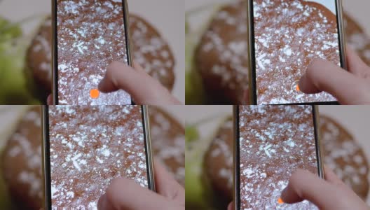 女性的手在用智能手机拍摄厨房里的巧克力派。变焦高清在线视频素材下载