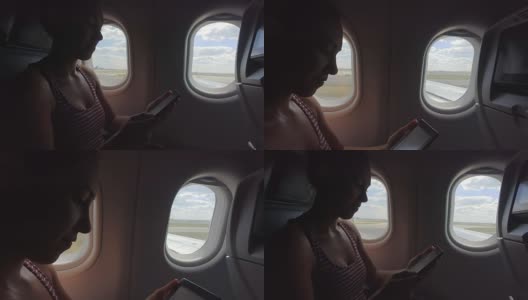 一名年轻女子在飞机上看电子书高清在线视频素材下载