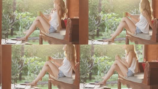 女孩在花园里喝咖啡/茶，欣赏日出/日落。高清在线视频素材下载