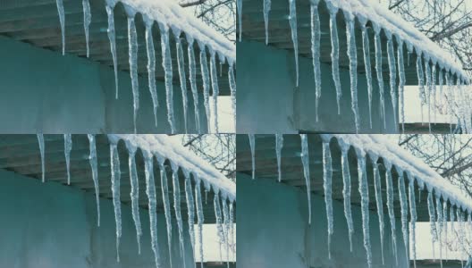 屋顶上正在融化的冬季冰柱滴着水高清在线视频素材下载