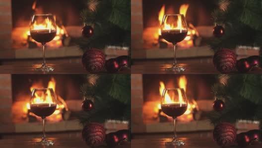 桌上放着杯中的红酒，映衬着燃烧的火焰高清在线视频素材下载